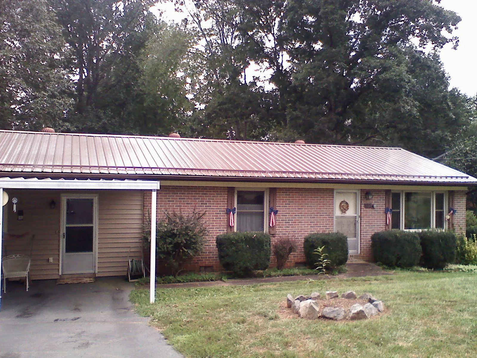 Bronze metal roof and carport on a brick ranch home — Roof Repair work by our crew in Echo
